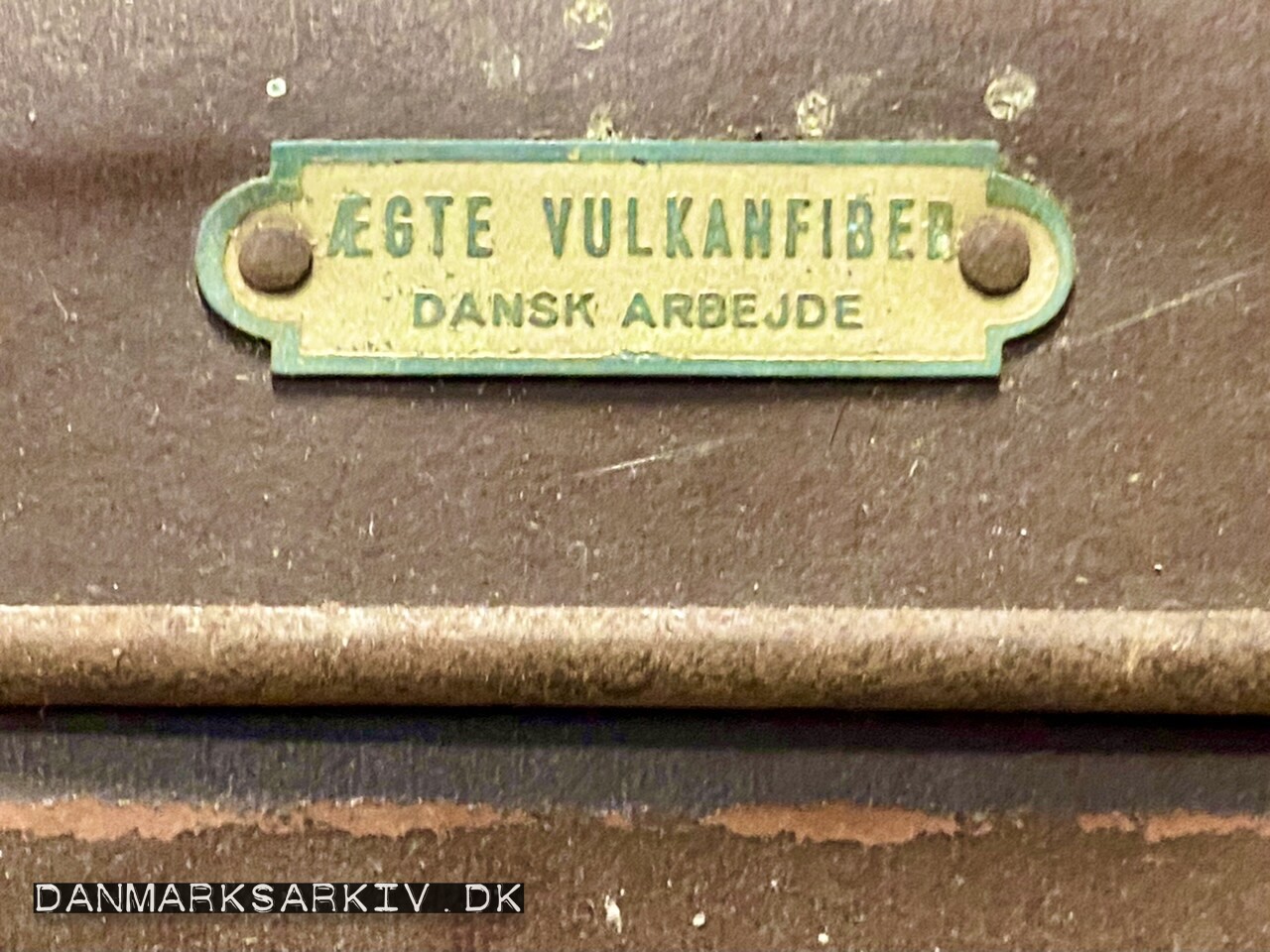 Kuffert med "Ægte Vulkanfiber - Dansk Arbejde" mærkat
