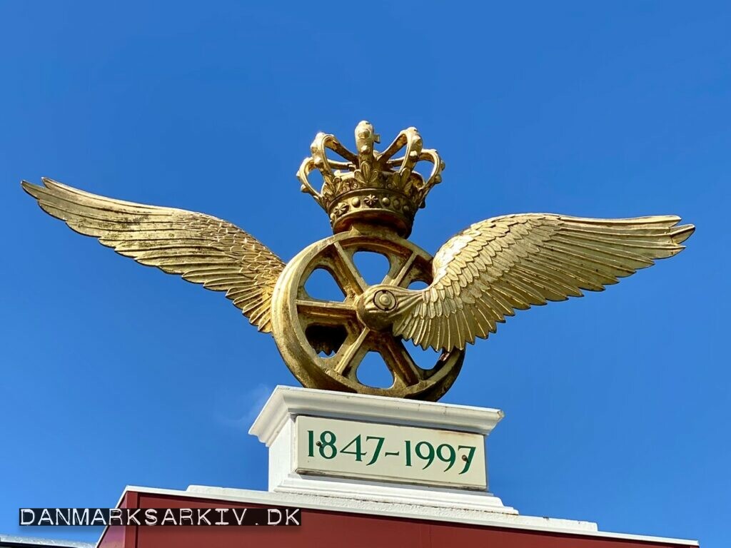 Gyldent vingehjul (DSB's logo) over indgangen til Danmarks Jernbanemuseum i Odense