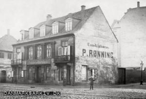 Vesterbros Materialhandel samt Theodor Hertz' kødudsalg på Vesterbrogade 61. På gavlen er en fin reklame for Cand. pharm: P. Rønning, der også havde en blækfabrik - 1880