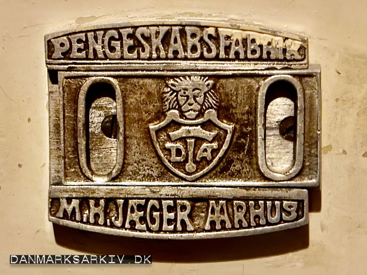 M. H. Jæger - Aarhus - Pengeskabsfabrik - Dansk Arbejde - Løve - Nøglehullet kommer til syne i åbningerne, når man skubber midterdelen til en af siderne.