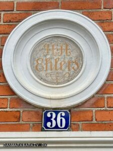 H A Ehlers står sirligt skrevet over døren på Søndre Stationsvej 36 i Slagelse - Ehlers drev en murermester- og entreprenørforretning.